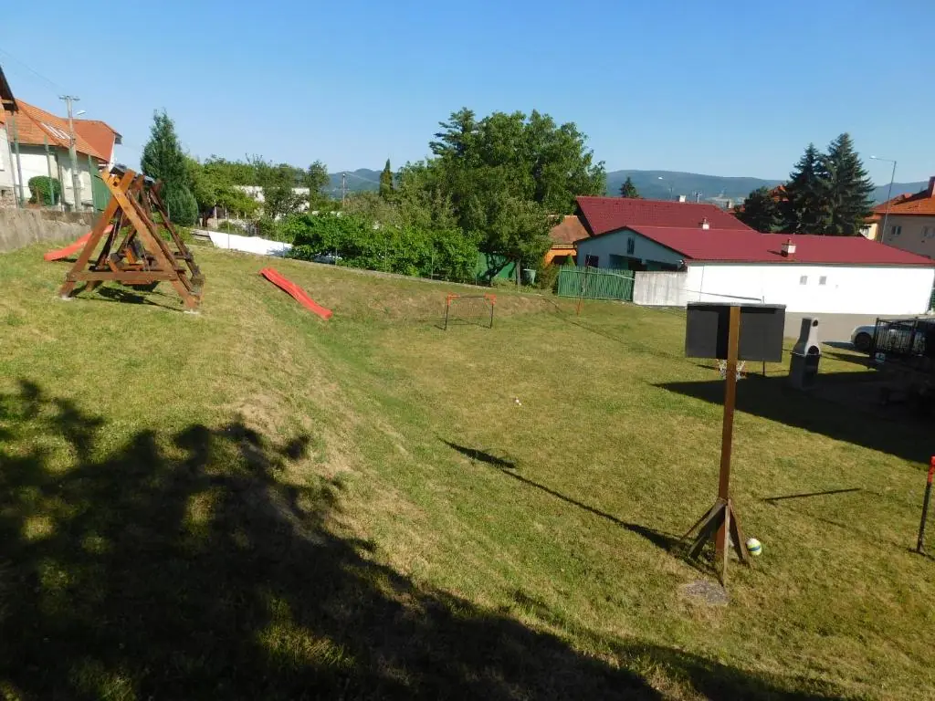 Hojdačka so šmykľavkou a futbalová bránka na dvore penziónu